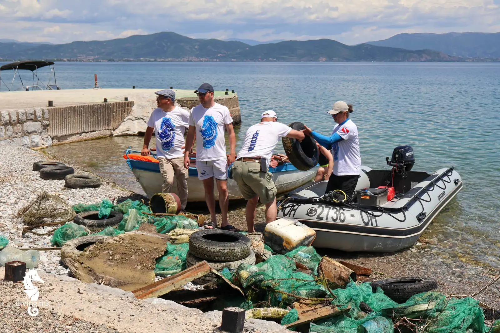 Amphibia scuba divers loading collected waste from Lake Ohrid into a rubber boat