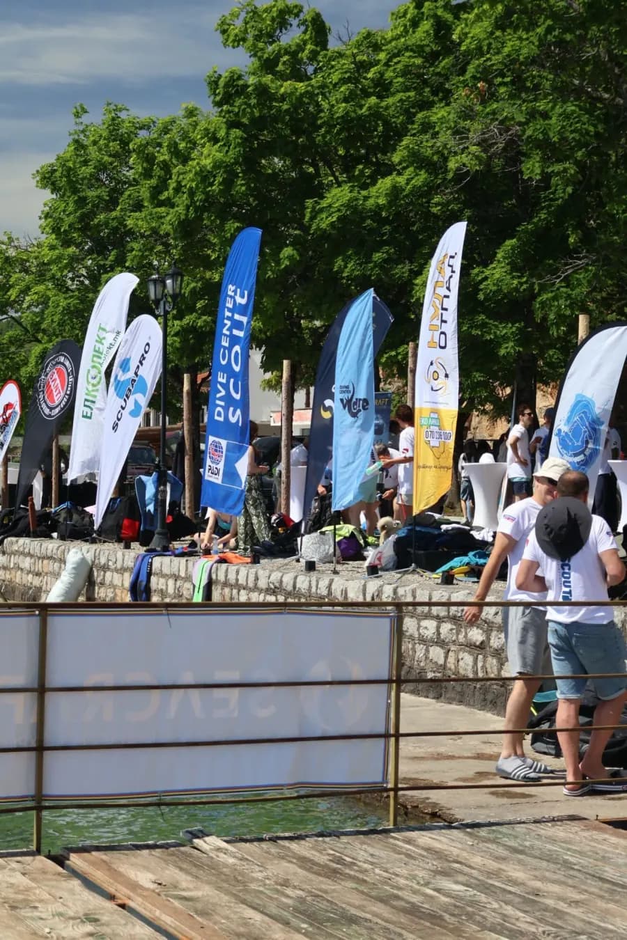 Flags of participating diving clubs lined up along the Lake Ohrid shore