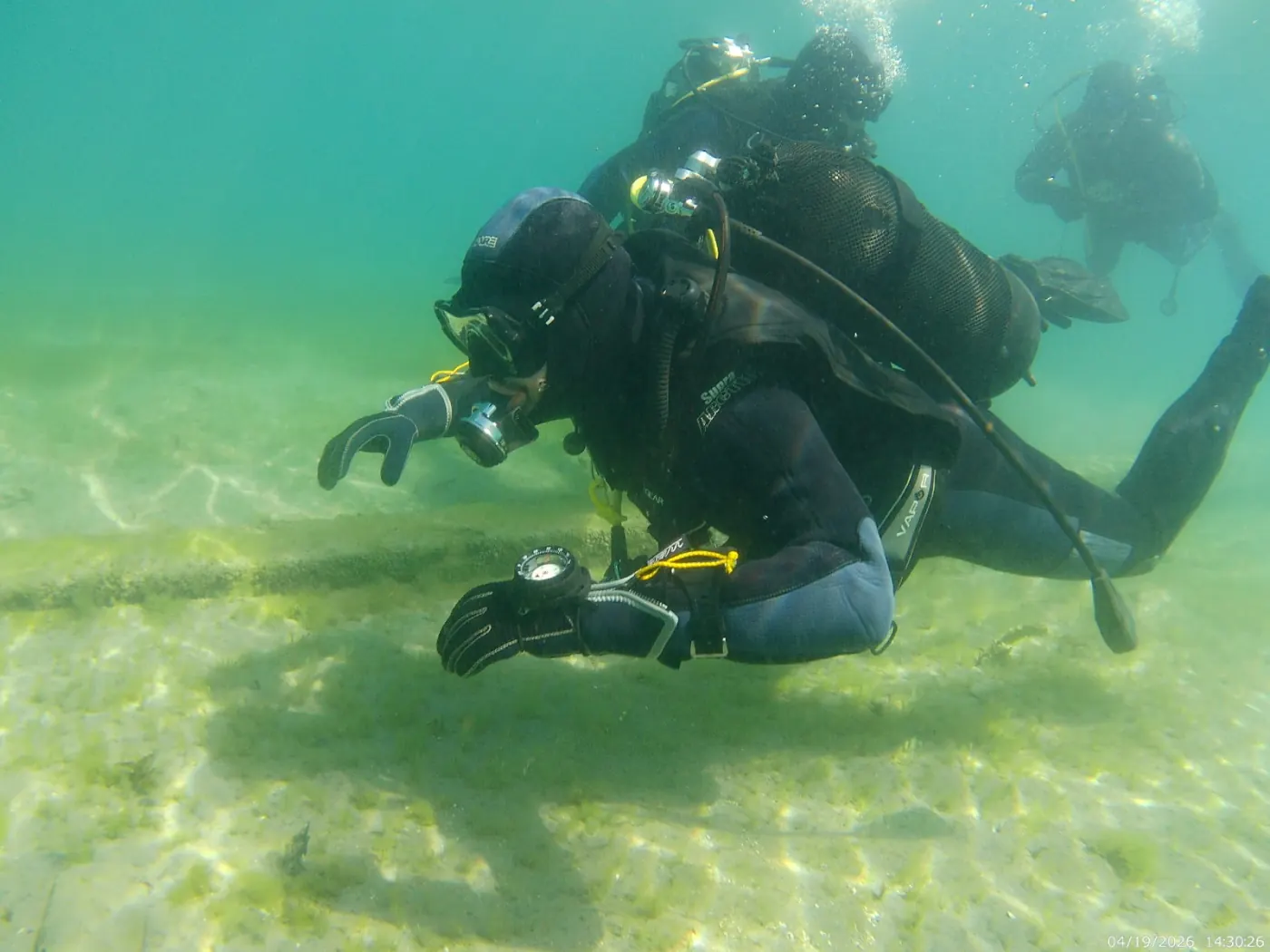 Underwater scene of scuba divers above the sandy floor of Lake Ohrid at Ljubaništa