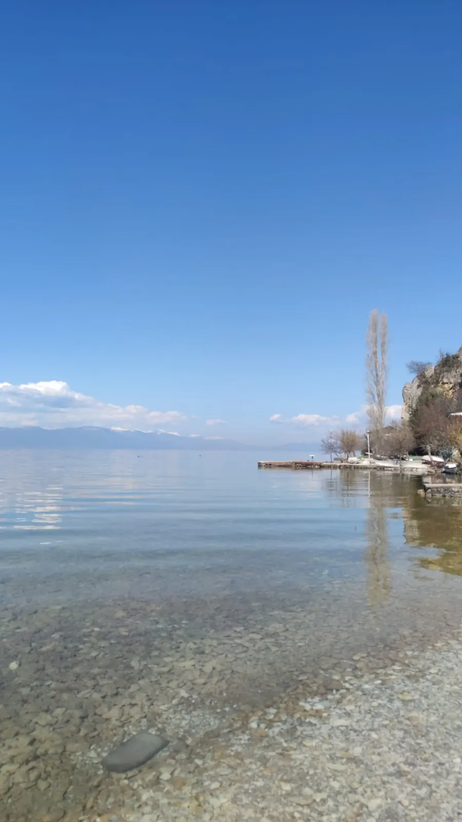 Crystal-clear shoreline of Lake Ohrid showing the pebbled bottom through transparent water
